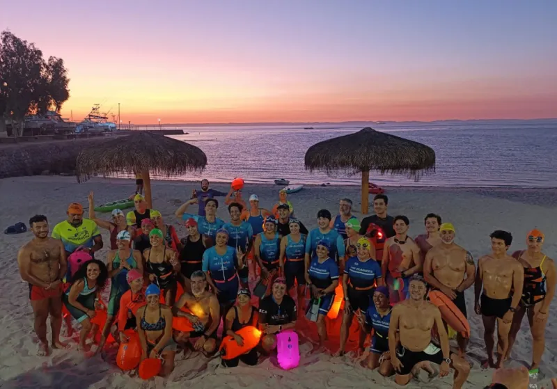 Grupo grande de nadadores posando en playa de La Paz