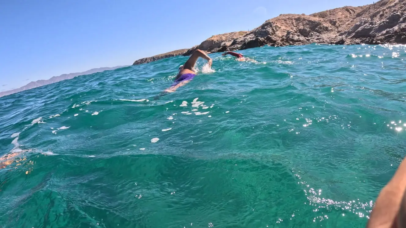 Natación estilo crol en aguas abiertas junto a rocas en La Paz